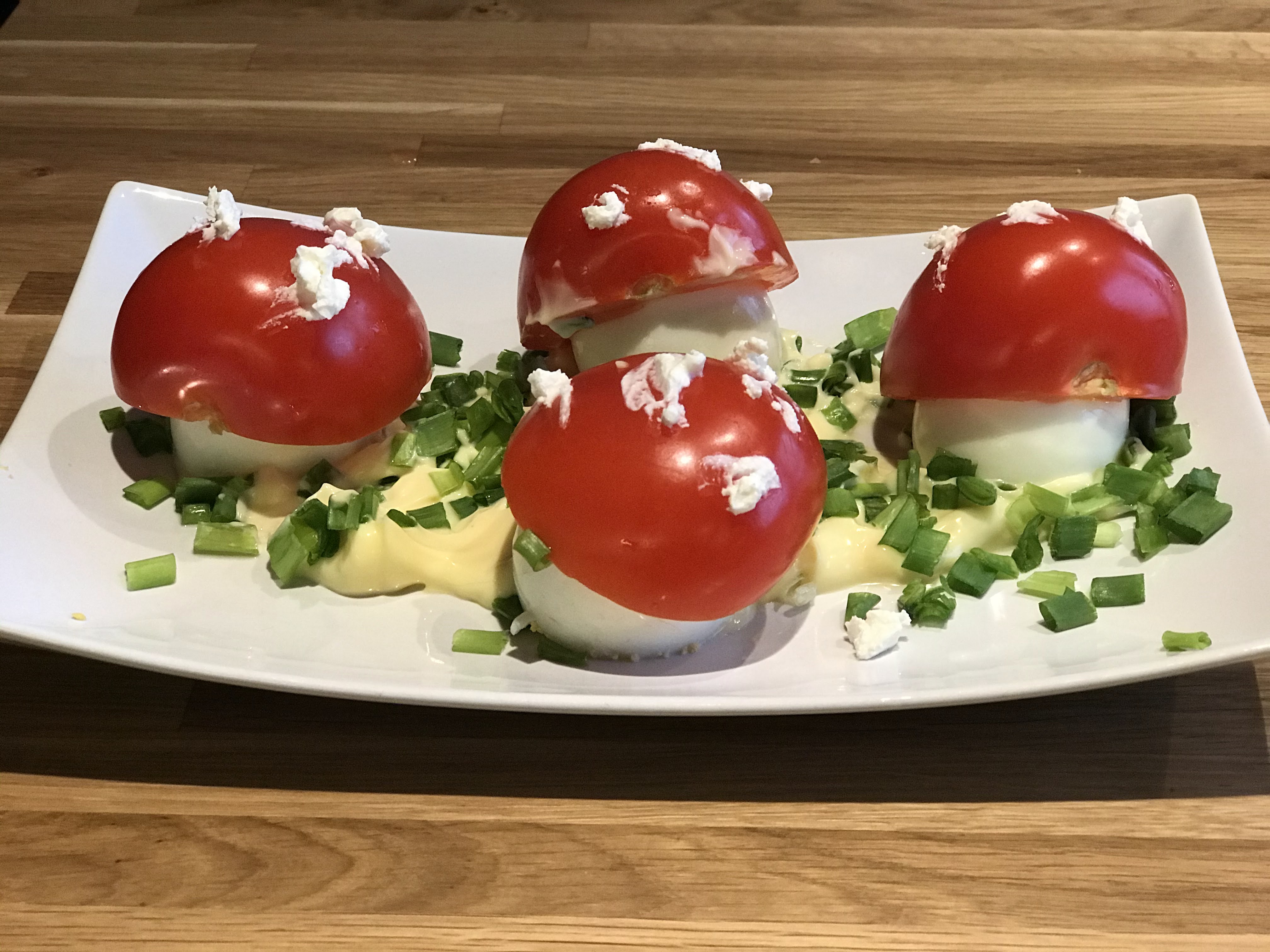 Talerz z potrawą, muchomory z jajek i pomidorów.